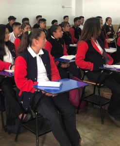 Conjunto de alumnos sentados en pupitres en un colegio de Quetzaltenango.