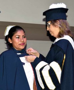 Decana poniendo pin en enfermera profesional