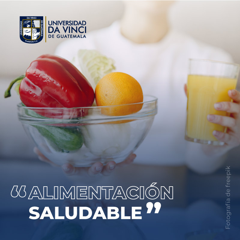 Fotografía de primer plano de un bowl lleno de verduras, en el fondo se ve el torso de una joven sentada sosteniendo un vaso con jugo de naranja, representando el taller de alimentación saludable.