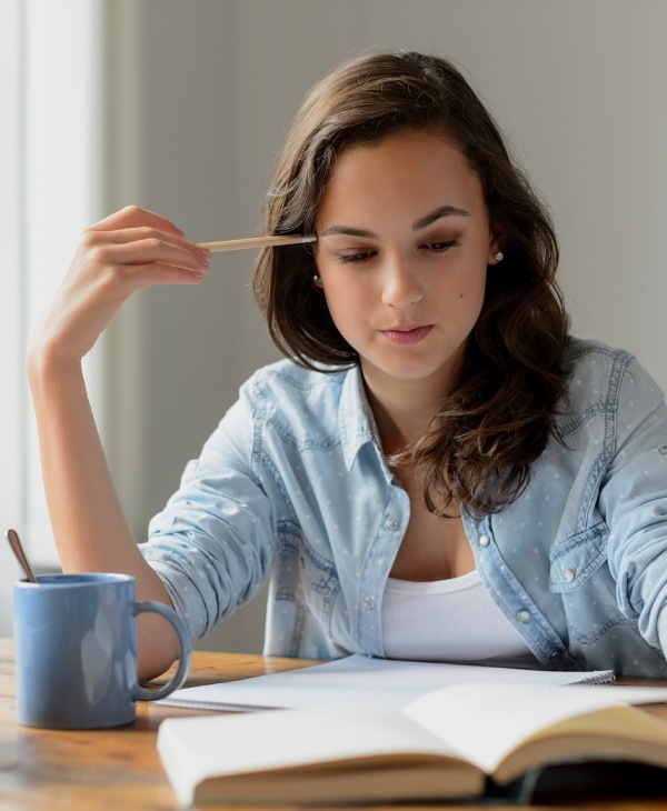 Una mujer vestida de celeste, libro, taza