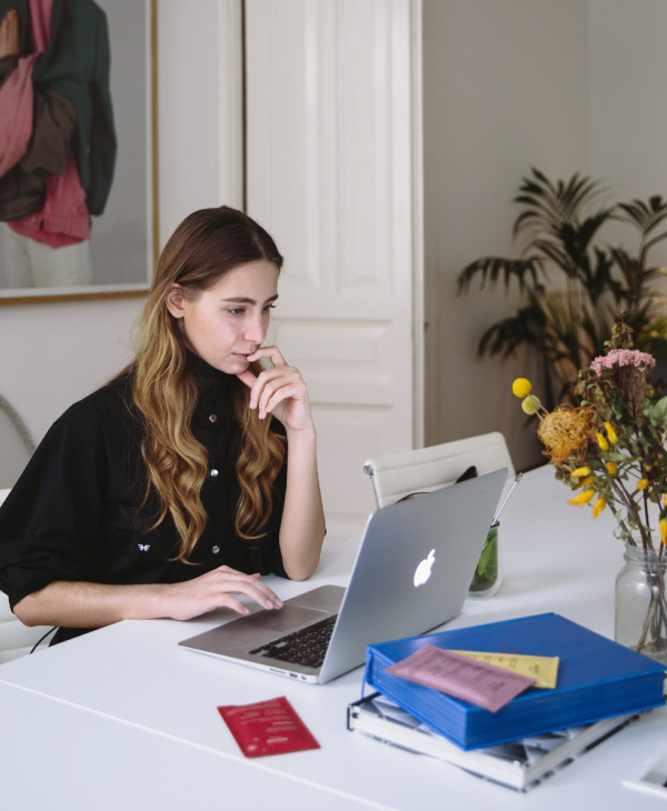 Una mujer vestida de negro, computadora, un escritorio