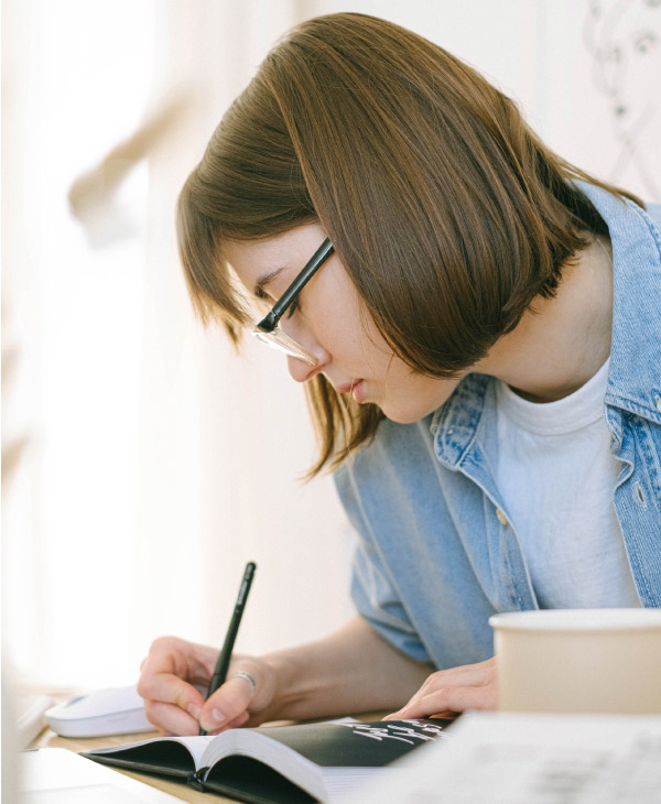 Una mujer escribiendo en un libro