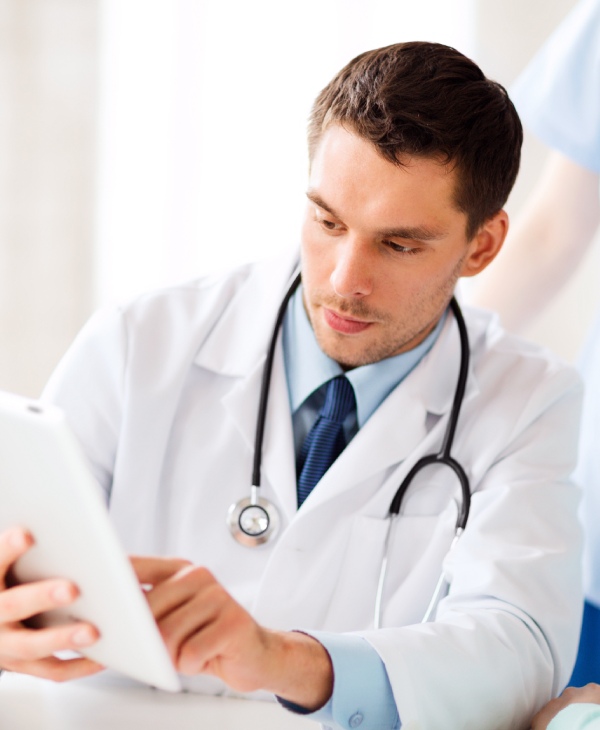 Un hombre con bata blanca y una tablet