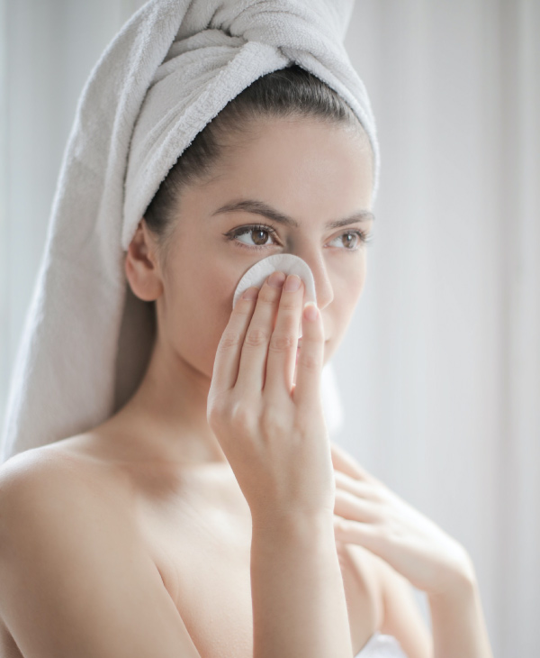 Una mujer con toalla en la cabeza y en la mano
